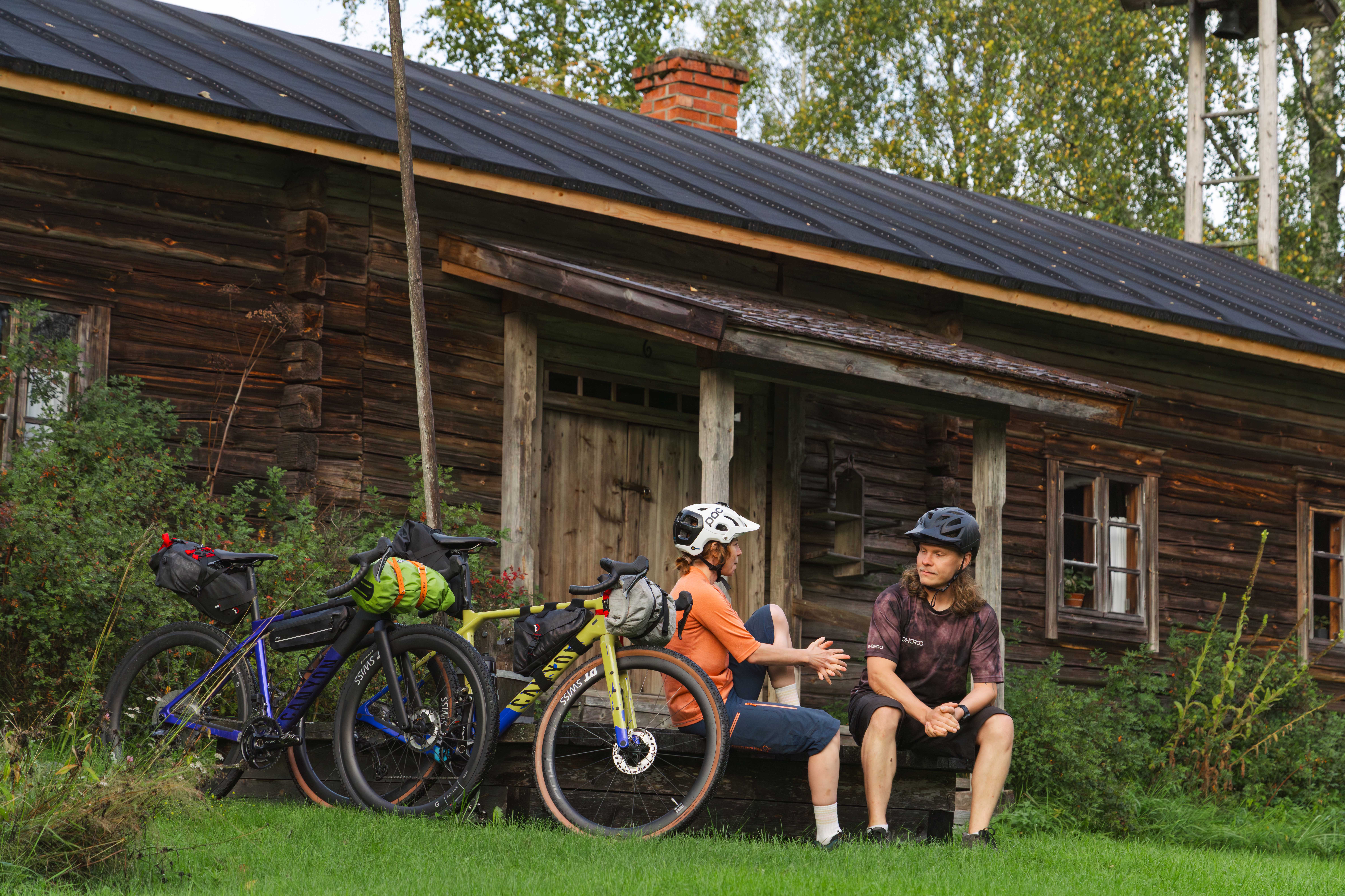 Kaksi pyöräilijää levähtää pirtin kuistilla